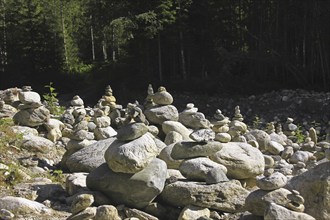 Cairns along the shore of river in forest of the Untersulzbachtal, Salzburgerland, Austria, Europe