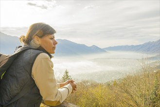 Woman Enjoy Panoramic View over Mountain Scape with a Foggy Valley in Locarno, Ticino, Switzerland,