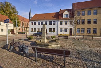 Benches with fountain, residential buildings and St Mary's Church at Altstädter Markt, Mühlberg