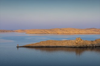 Tranquil seascape with golden islands under a blue sky and gentle waters, Pag, Croatia, Europe