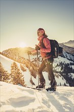 A woman's ski tour at sunrise on the Tegelberg in the Allgäu in the Ammergebirge, Bavaria, Germany,