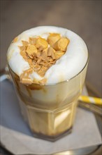 A latte with a creamy topping and biscuits served on a table, autumn creations, Cafe Kuh,