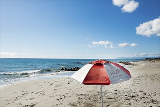 Lonely beach and parasol, Spiaggia di Biderosa, Riserva Biderosa nature reserve, Orosei, Nuoro