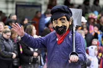 Person masked as farmer, field worker at the carnival parade of the Wey guild on Rose Monday,