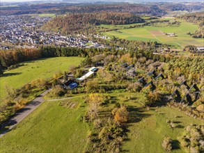 Wide landscape with autumn colours, fields and a small village in hilly surroundings, high ropes