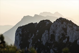 Lone mountaineer on the summit of the Hörndlwand in the Chiemgau Alps with the silhouette of