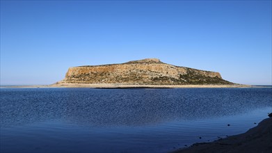 Rocky island in front of calm blue sea under clear sky, peaceful scene, Gramvoussa, Gramvoussa