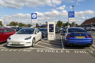 Electric vehicles charging Pod Point, Tesco Extra supermarket carpark, Swindon, Wiltshire, England,