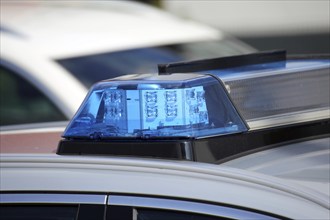 Symbolic image: Close-up of a police car with flashing blue lights