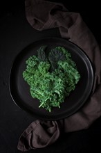 Food background, on a black table, top view, Fresh Kale leaves, close-up, vertical, no people,