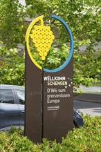 Welcome sign for Schengen with a graphic grape motif and green background, Schengen, Canton of