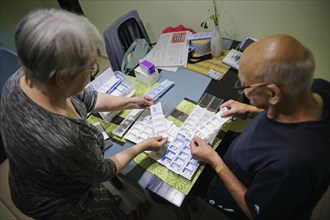 Symbolic photo on the subject of taking medication in old age. Two senior citizens sort various