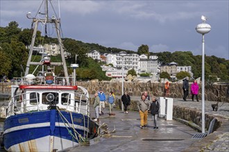 The city harbour of Sassnitz, island of Rügen, fishing boats, pier, behind the old town,