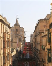 Flags decorate historic street in city centre of Valletta, Malta, Europe