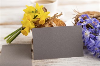 Gray paper business card mockup with oatmeal cookies with spring snowdrop flowers bluebells,