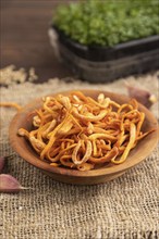 Fresh Cordyceps militaris mushrooms on brown wooden background with microgreen, herbs and spices.