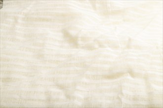 Fragment of smooth white linen tissue. Side view, natural textile background and texture