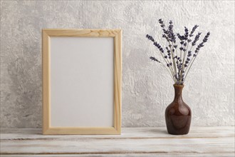 White wooden frame mockup with lavender in ceramic vase on gray concrete background. Blank,