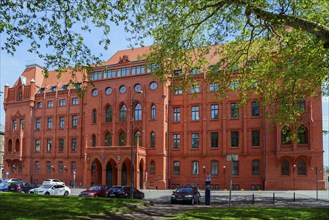 A historic red brick building in Gothic style on a sunny day with blue sky, City Hall, Szczecin,