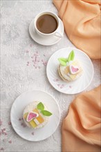 Decorated cake with milk and coconut cream with cup of coffee on a gray concrete background and