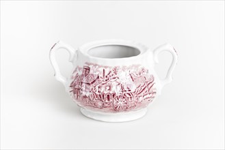 White and red ceramic sugar bowl with a country house pattern and two handles on a light-coloured