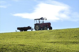 Old tractor with trailer standing on an alpine meadow, Nesselwang, 14.10.2021