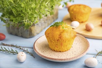 Homemade cakes with chocolate eggs and mizuna cabbage microgreen on a blue wooden background. side