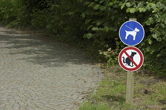 Signs 'Dog excrement prohibited' and 'Dogs on a lead' in a park, North Rhine-Westphalia, Germany,