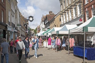 People shopping in busy pedestrianised street in Winchester, Hampshire, England, UK