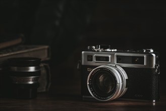 Vintage camera with lens on a dark wooden table