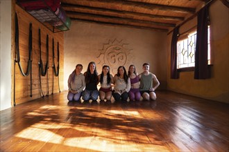 Group portrait of a community of people practicing yoga smiling and looking at the camera. General