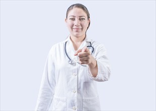 Smiling female doctor pointing at the camera. Happy female doctor pointing at you, Young doctor