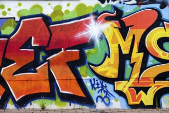 Colourful graffiti on an urban wall shows artistic lettering and vibrant colour design,