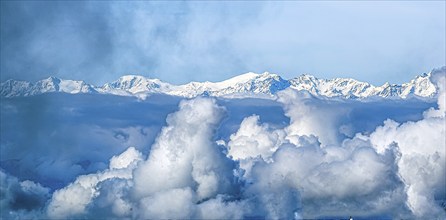 Snow-covered mountain range under a sea of clouds and blue sky, Val Gardena, South Tyrol, Italy,