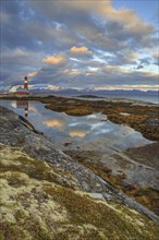 Lighthouse reflected in water, cloudy mood, mountains, coast, Tranoy, Ofoten, Norway, Europe