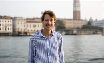 Young man in striped shirt, portrait, on the banks of the Grand Canal, behind Campanile, Venice,