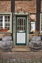 Entrance area of a restaurant in a historic half-timbered brick house with entrance door, white