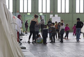 Children of refugees playing between tents in an emergency shelter for refugees on 9 December 2015