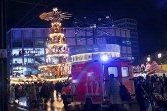 An ambulance from the Berlin fire brigade next to a Christmas pyramid at the Christmas market on