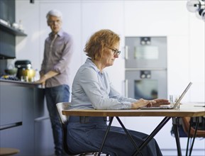 Symbolic photo on the subject of division of labour for couples in the household. A woman sits at a