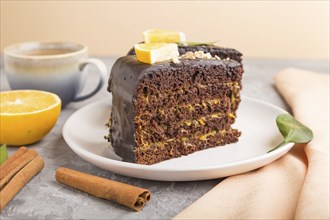 Homemade chocolate cake with orange and cinnamon with cup of coffee on a gray concrete background