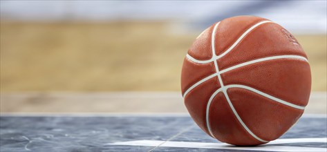 Close-up of basketball on the floor of a hall (with free space for text or logo)