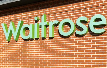 Waitrose shop sign on brick wall, UK