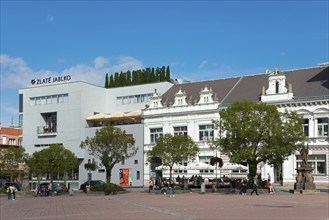 Modern and historical building on a busy square on a sunny day, Houses on Peace Square, Namesti