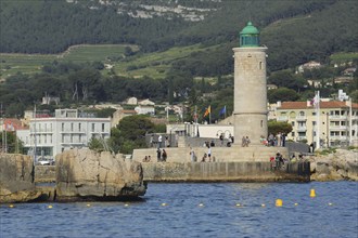 Lighthouse and people on the shore, Mediterranean coast, Cassis, Bouches-du-Rhône, Provence,