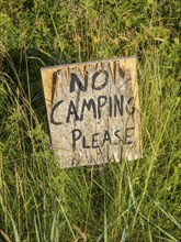 No camping sign put into the grass, beach on Senja island, Norway, Europe