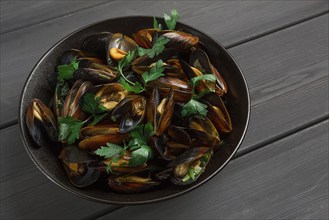 Fresh, Boiled mussels, Black Sea, with parsley and lemon, on a wooden table, no people