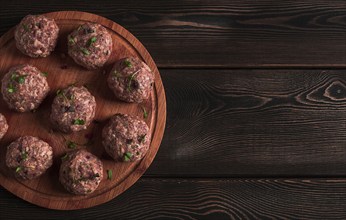 Raw meatballs, with micro greenery, on a cutting board, homemade, rustic, no people