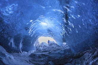 Tourist at the entrance of an ice cave, glacier cave, Vatnajökull, Iceland, Europe