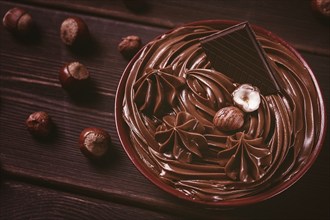 Chocolate nut paste, mousse, pasta, in a cup, on a wooden table, top view, selective focus, no